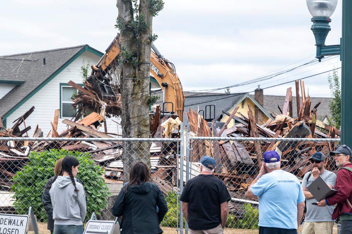 A group with Save Ryan House watches the demolition of the 160-year-old home on Friday, July 25, 2025, in Sumner, Wash.
