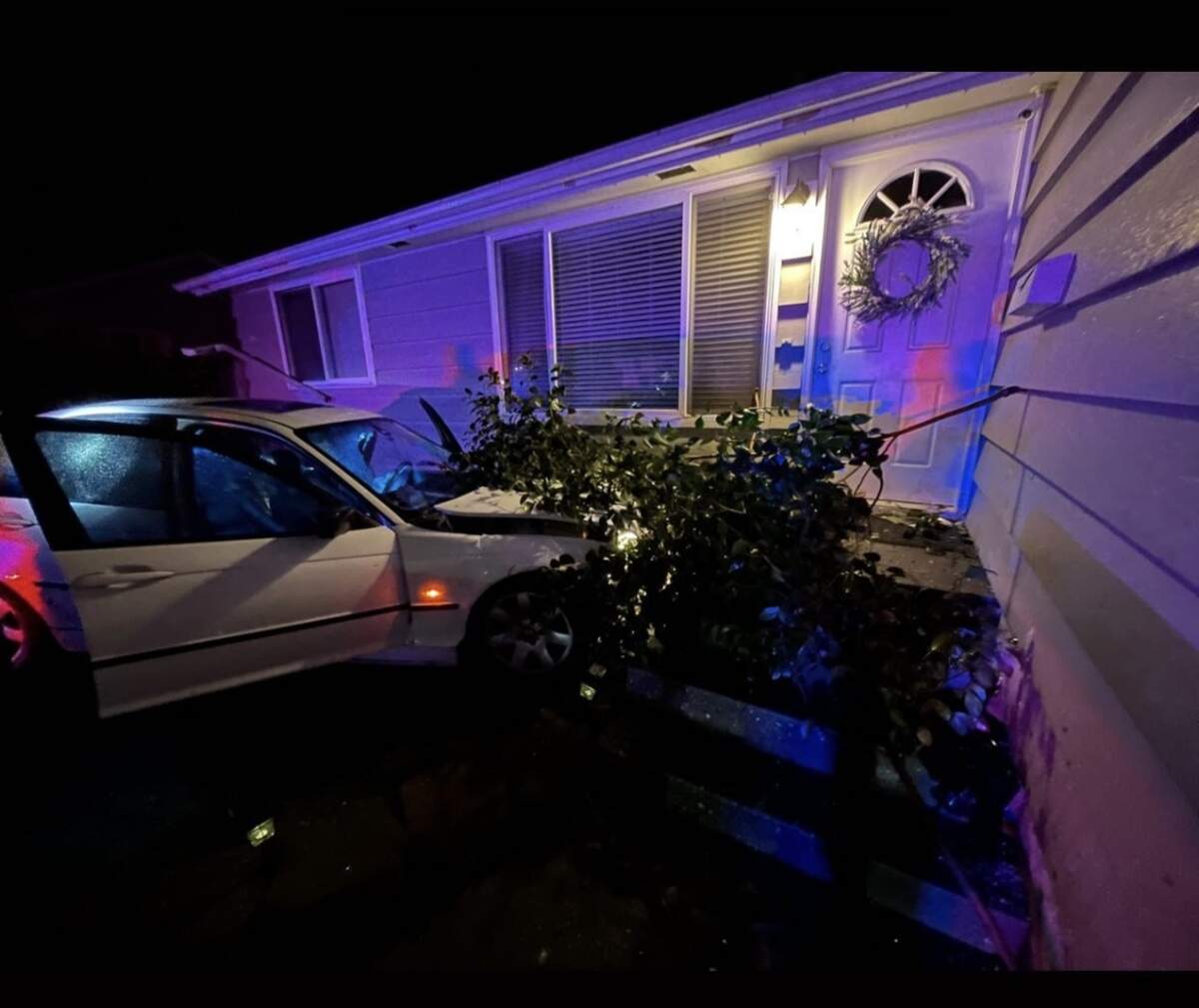 A BMW sedan rests against a home on North Pearl Street on the night of Sunday, Jan. 15, after its 16-year-old driver was shot. The car careened through the yards of three homes before crashing into this house.