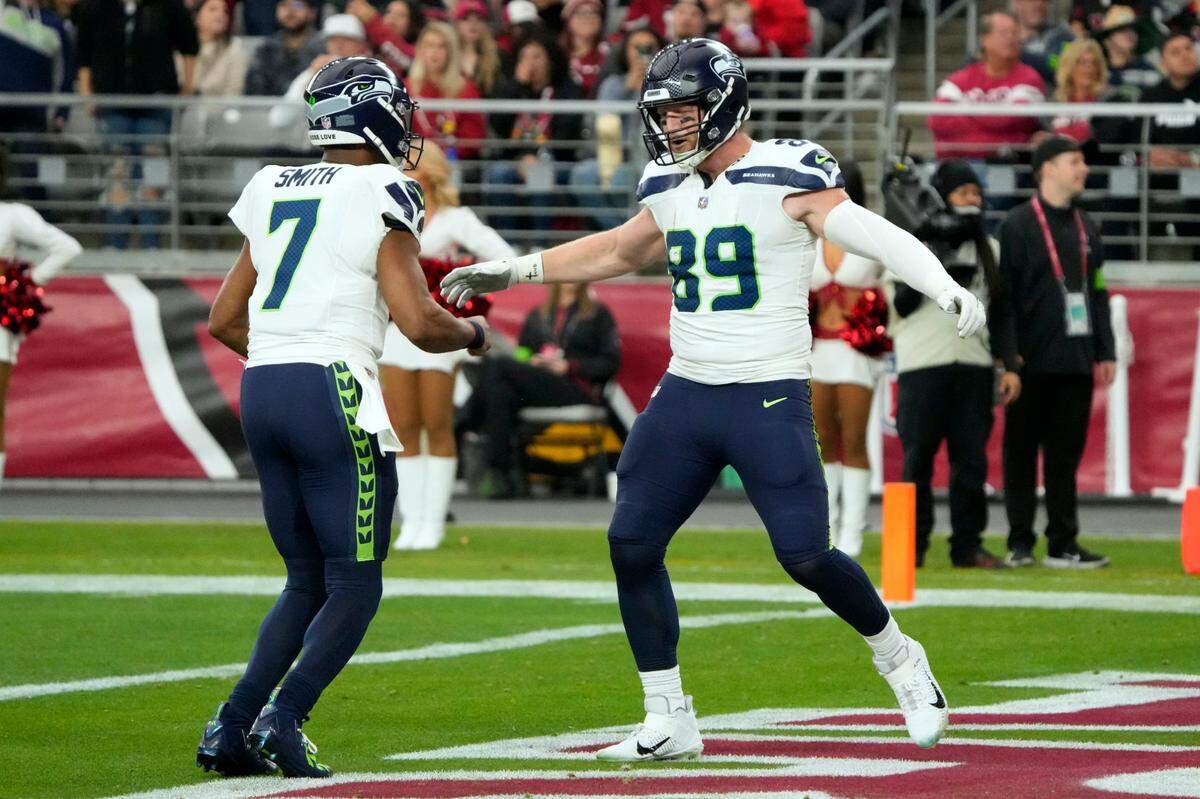 Seattle Seahawks tight end Will Dissly (89) celebrates with quarterback Geno Smith (7) after they teamed up on a 19-yard touchdown pass play against the Arizona Cardinals in the first half of an NFL football game Sunday, Jan. 7, 2024, in Glendale, Ariz. (AP Photo/Rick Scuteri)