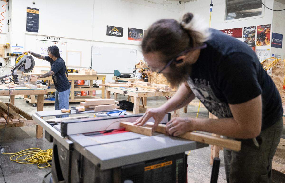 Jack Hagey, construction Technology instructor, front, uses a table saw as Jenny Nguyen, student, cuts wood at the Clover Park Technical College’s new Eastside Training Center on Friday, July 18, 2025, in Tacoma.