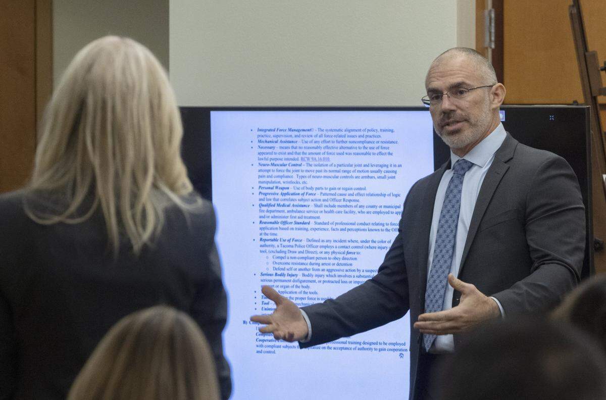Chris Nielsen, right, a use-of-force expert, talks about the Tacoma police use of force policy form, projected on screen, to defense attorney Anne Bremner during the trial of three Tacoma Police officers in the killing of Manny Ellis at Pierce County Superior Court, Wednesday, Nov. 29 2023, in Tacoma, Wash. Tacoma Police Officers Christopher Burbank, Matthew Collins and Timothy Rankine stand trial for charges related to the March 2020 killing of Manny Ellis. (Ellen M. Banner / Pool / The Seattle Times)