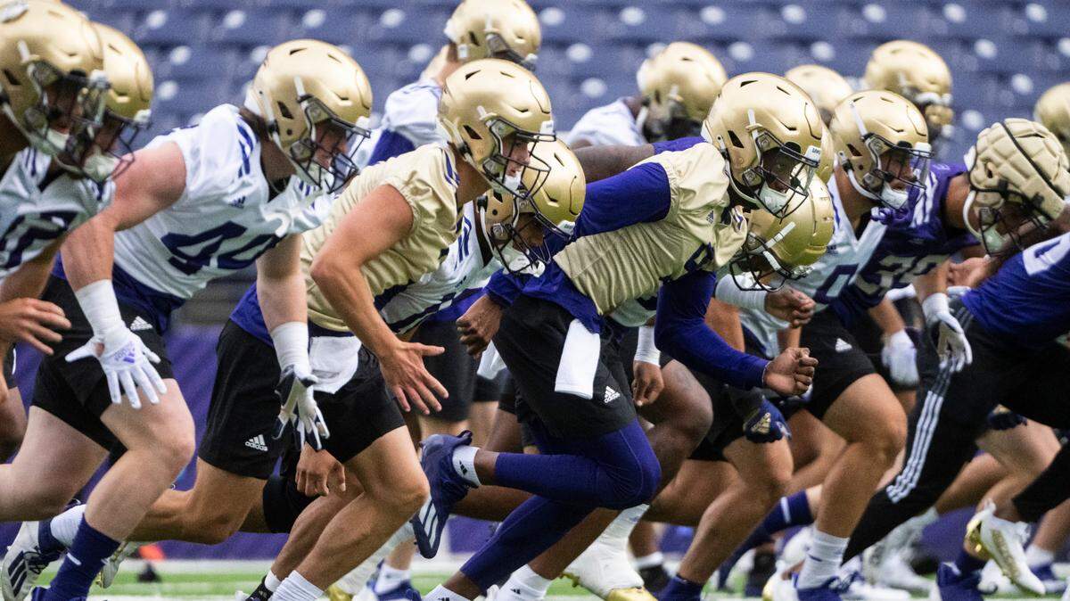 University of Washington Huskies quarterback Michael Penix Jr., 9, runs down the field with his teammates during a drill at the first day of Fall practice at Husky Stadium on Thursday, Aug. 4, 2022 in Seattle, Wash.