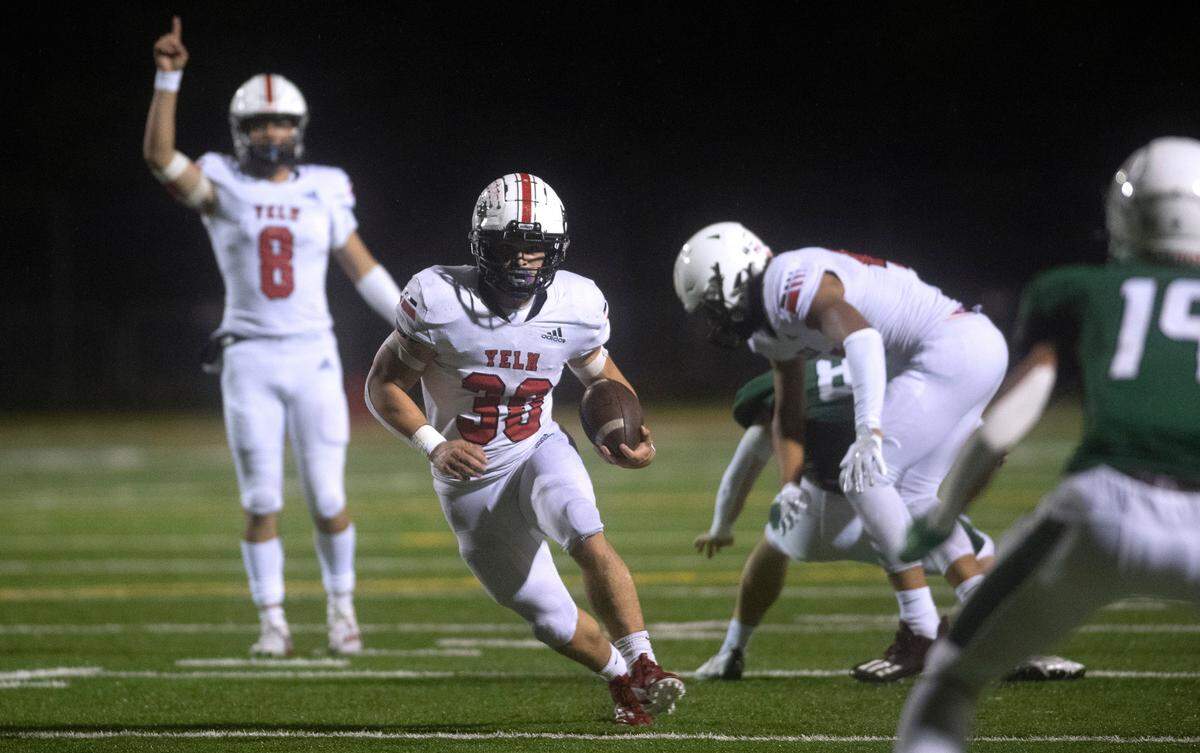 Yelm running back William Carreto breaks loose in front of quarterback Damian Aalona during Friday night’s football game against the Peninsula Seahawks at Roy Anderson Field in Purdy, Washington, on Oct. 21, 2022.