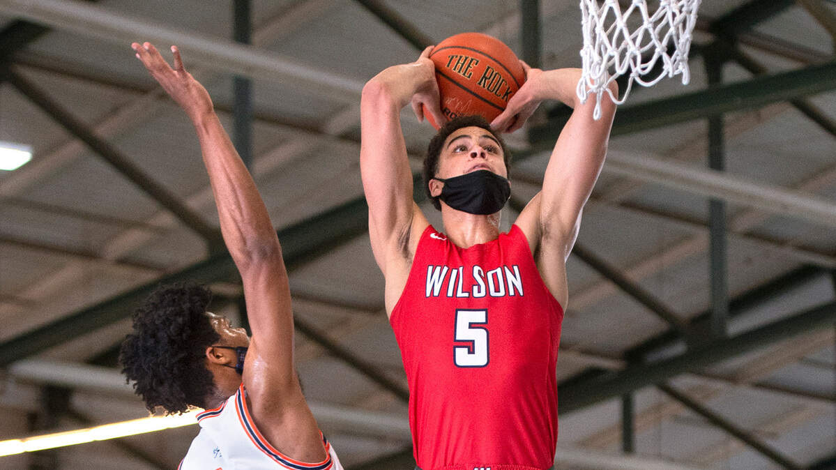 Wilson’s Jackson Dorsey slams home a dunk in front of Lakes defender TJ Green during Thursday night’s high school basketball game on the arena courts at the Washington State Fairgrounds in Puyallup, Washington, on Thursday, May 13, 2021. Wilson won the game, 93-46.