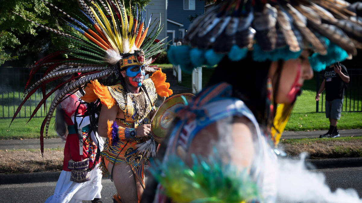 Victor Maldonado leads dancers as they march south on Portland Avenue to the Dia de los Muertos celebration at the Eastside Community Center in Tacoma, Washington, on Saturday, Oct. 29, 2022.