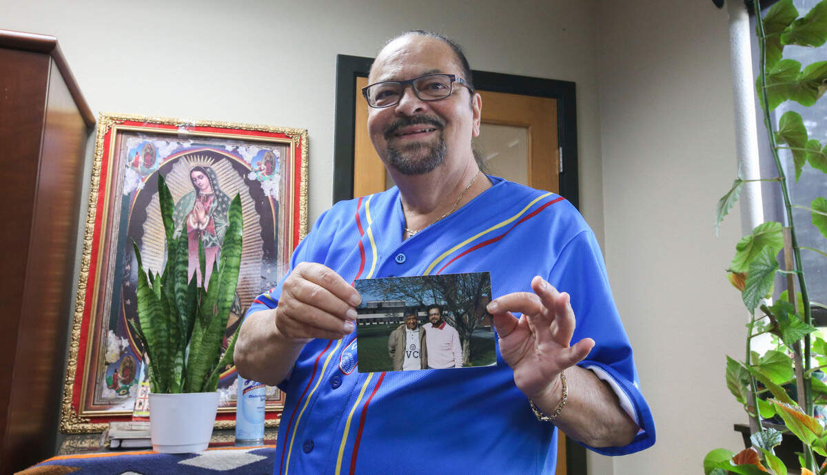Bernal Baca, executive director of Mi Centro, holds a photo of him and Cesar Chavez, a labor and civil rights activist who co-founded the United Farm Workers labor union. Baca said Chavez was a good friend of his.