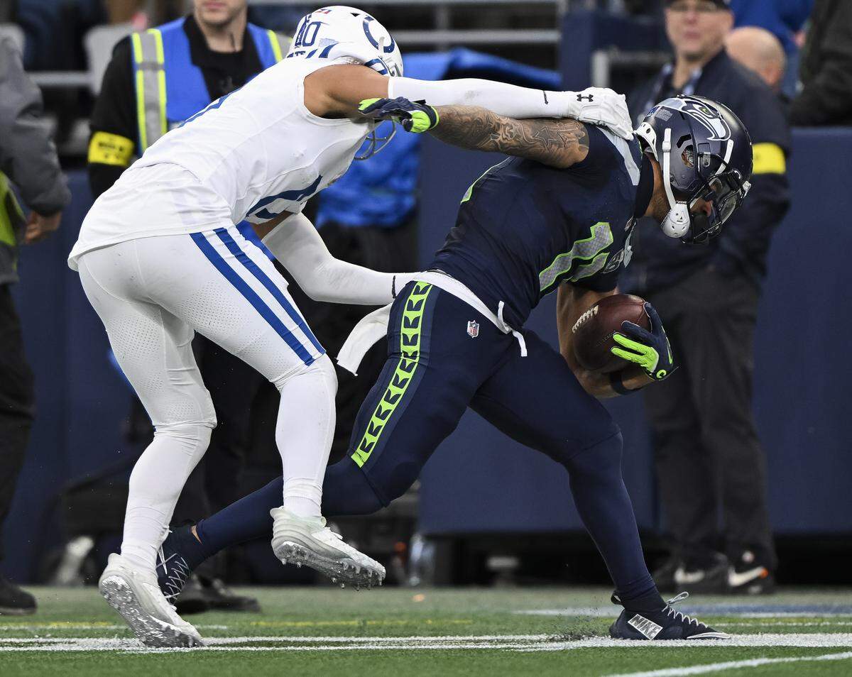 Seattle Seahawks wide receiver Jaxon Smith-Njigba (11) is pushed out of bounds by Indianapolis Colts safety Cam Bynum (0) during the third quarter of the game at Lumen Field, on Sunday, Dec. 14, 2025, in Seattle.
