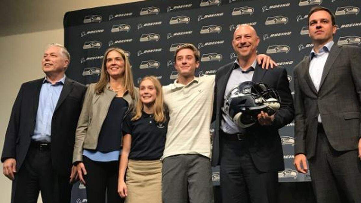 Tacoma native, Curtis High graduate Chris Arnold (holding helmet) with his family immediately to his right after being promoted from chief operating officer to Seahawks president on Monday. On the flanks: team vice chairman Bert Kolde (left) and new Vulcan Sports and Entertainment CEO Chris McGowan (far right).