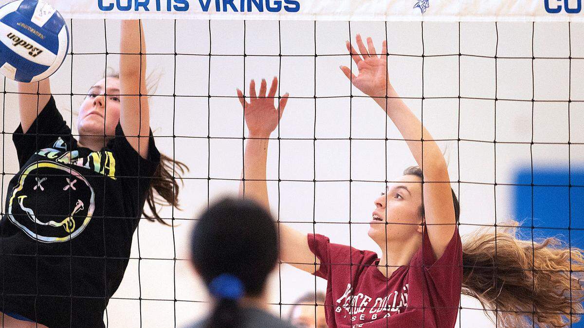 Curtis freshman Ariana Medchill (left) and senior Rudi Reyes guard the net during volleyball practice at Curtis High School in University Place, Washington, on Wednesday, Nov. 17, 2021.