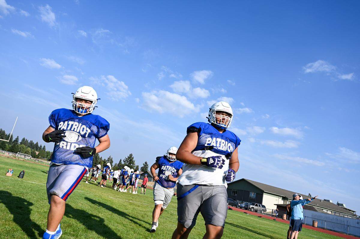 Washington student-athletes run to drill stations during a practice at Washington High School, Monday, Aug. 21, 2023, in Tacoma, Wash.