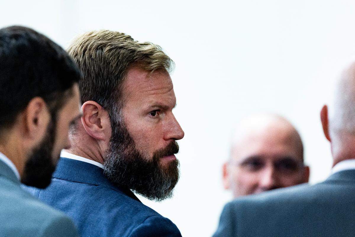 Matthew Collins, one of the Tacoma officers on trial in the death of Manual Ellis, meets with the defense team Wednesday, Nov. 1, 2023, at Pierce County Superior Court in Tacoma. (Luke Johnson / Pool / The Seattle Times)