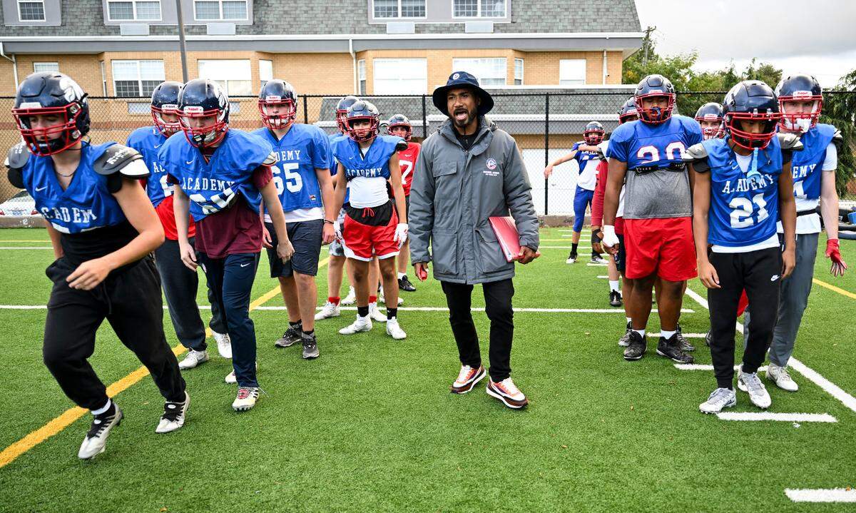 Life Christian Academy head football coach Hershel Dennis speaks to players as they run drills during a practice at Life Christian Academy, Wednesday, Oct. 11, 2023, in Tacoma, Wash. Dennis is a two-time national title winning running back at USC and one of the winningest athletes in college football.