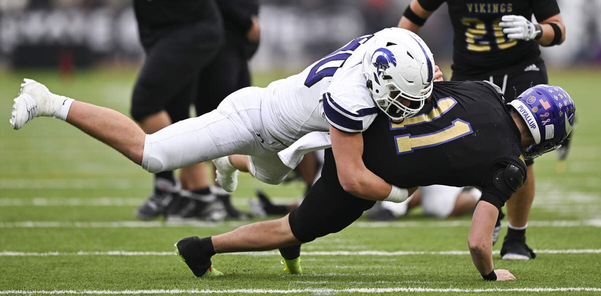 Sumner defensive end Shaun Griffith (90) sacks Puyallup quarterback Noah Smith (11) during the second half of the 4A state semifinal game at Sparks Stadium, on Saturday, Nov. 29, 2025 in Puyallup.