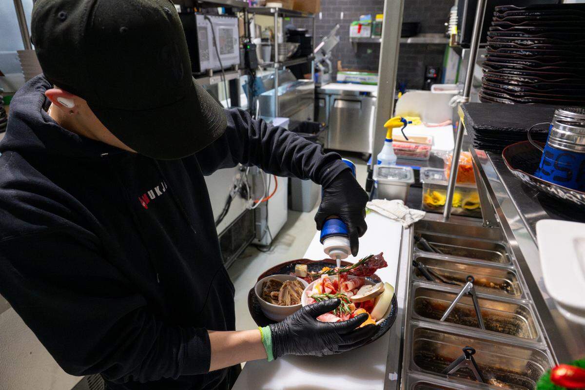 Edixon Garcia prepares a Mukja Beef Combo, or Combo C, in the kitchen of restaurant Mukja Korean BBQ on Friday, April 18, 2025, in Puyallup, Wash. The combination of meats, which includes boneless short rib, beef brisket and LA-style galbi, comes with rice, salad, side dishes and kimchi or soybean stew.