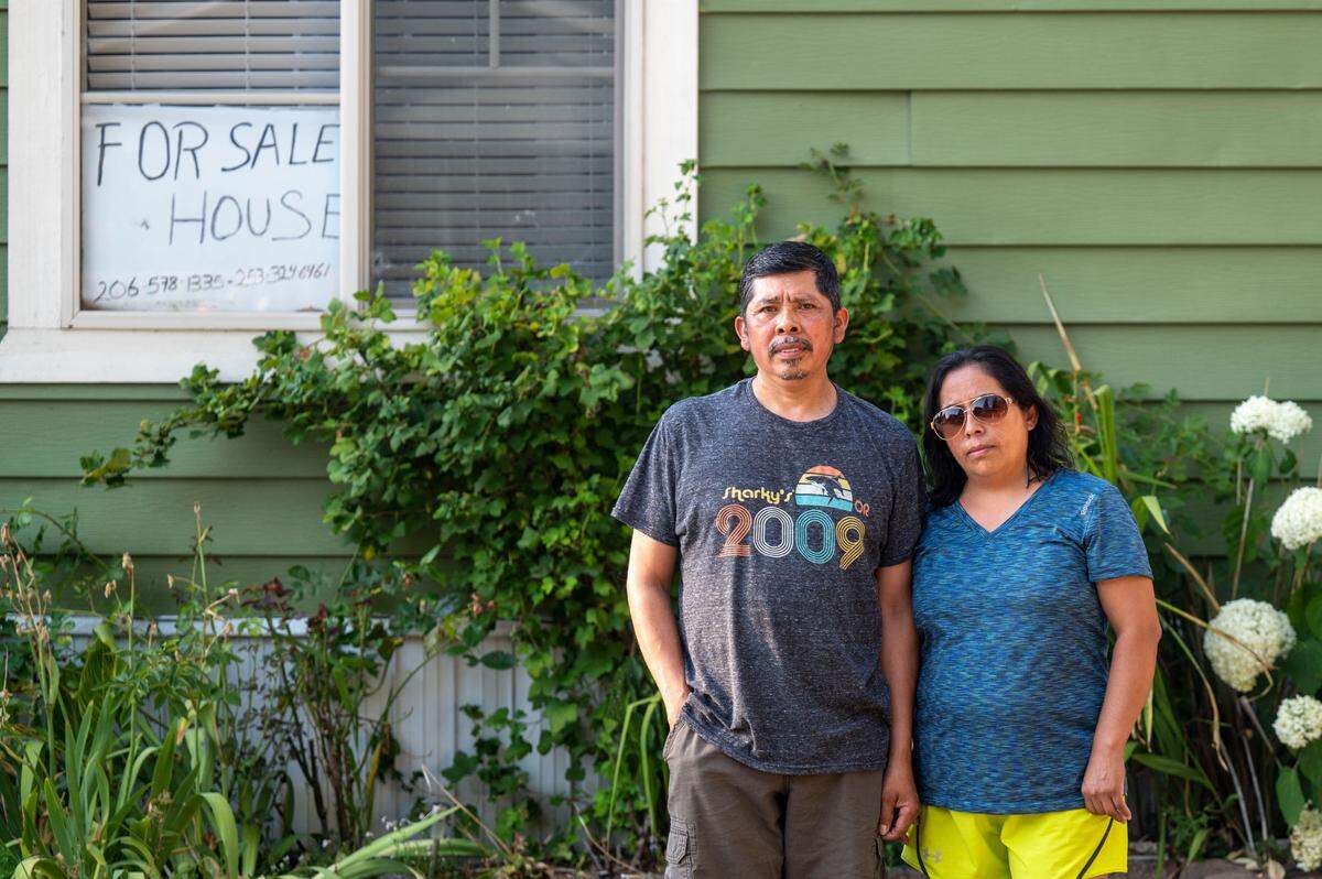 Martin Martinez and his wife, Cristina Nieto, pose for a portrait in front of their home at Meridian Estates in Puyallup, Wash., on Wednesday, July 27, 2022. The couple has lived at their house in the mobile home park for 11 years and will have to move out by October.