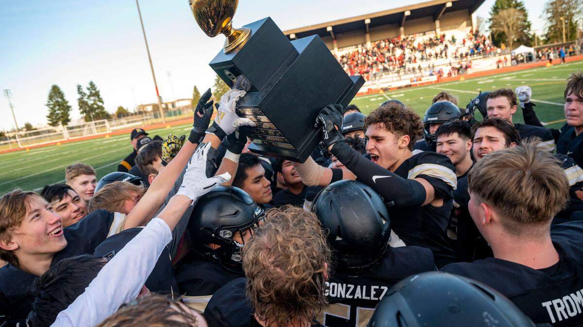 Royal players celebrate by hoisting the Class 1A football trophy after beating Mount Baker, 35-20, in the state championship game on Saturday, Dec. 3, 2022, at Harry E. Lang Stadium in Lakewood, Wash.
