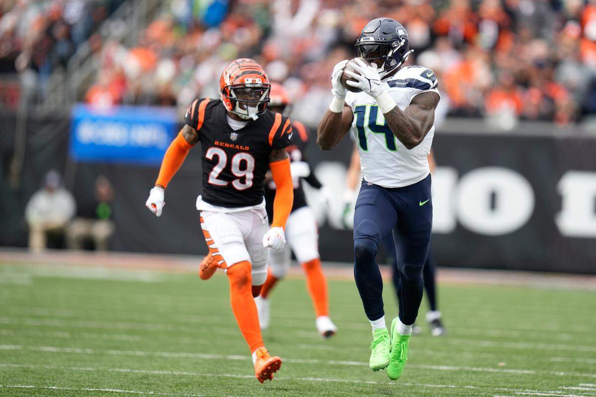 Seattle Seahawks’ DK Metcalf (14) makes a catch against Cincinnati Bengals’ Cam Taylor-Britt (29) during the second half of an NFL football game, Sunday, Oct. 15, 2023, in Cincinnati. (AP Photo/Michael Conroy)