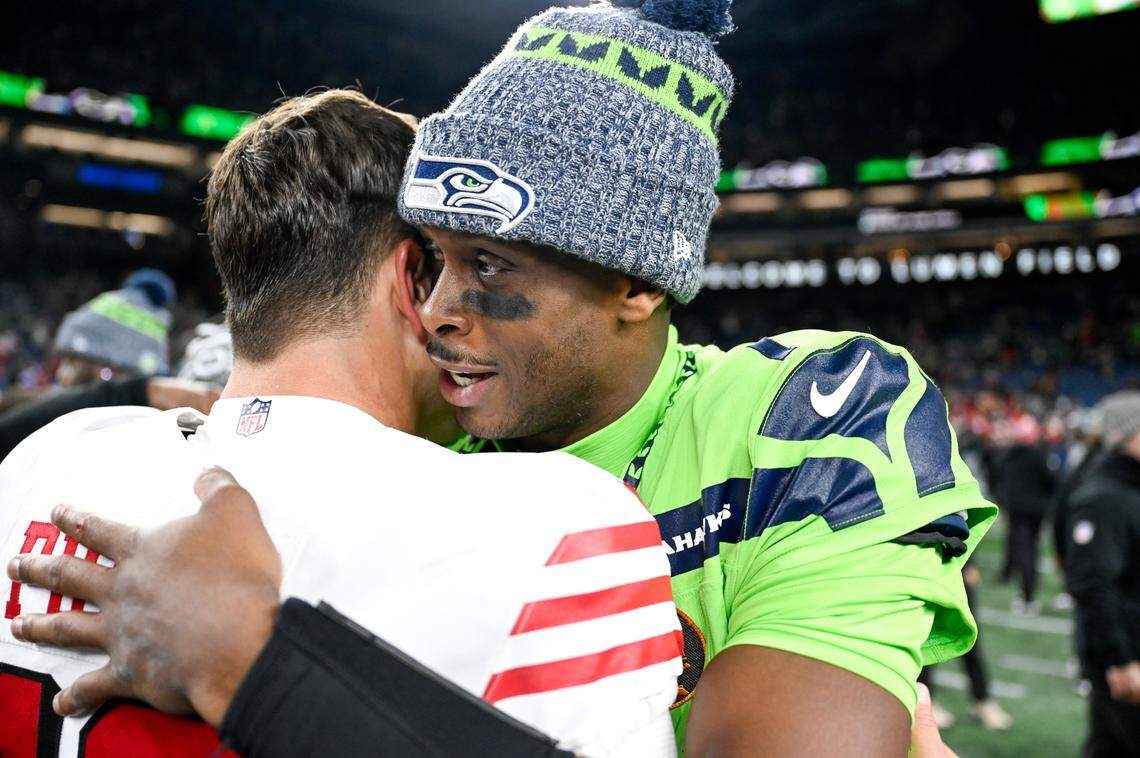 Seattle Seahawks quarterback Geno Smith (7) and San Francisco 49ers quarterback Brock Purdy (13) hug after the 49ers 31-13 victory at Lumen Field, Thursday, Nov. 23, 2023, in Seattle, Wash.