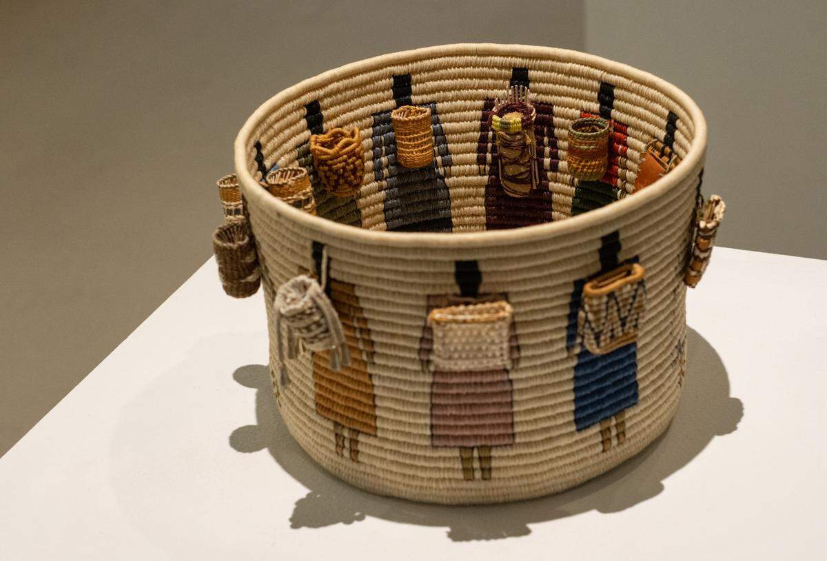 “Cultural Burdens III” by Northern Arapahoe and Seminole artist Carol Emarthle Douglas depicts a series of women – each carrying a miniature woven basket or a small cradle board with a baby on their back – on display at “The Longhouse at 25: Across the Waters’’ exhibit celebrating the 25th anniversary of the Longhouse Education and Cultural Center. The exhibit is on display until Jan. 29 at the Evergreen Gallery at Evergreen State College in Olympia. The design can be seen from the inside and outside of the basket, intricately woven with waxed linen, red and yellow cedar bark.
