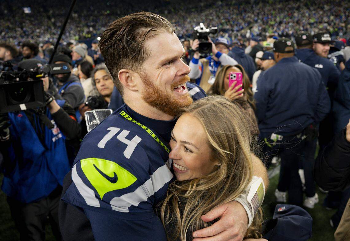 Seattle Seahawks quarterback Sam Darnold (14) and partner Katie Hoofnagle embrace after the Seattle Seahawks win the NFC Championship against the Los Angeles Rams at Lumen Field, on Sunday, Jan. 25, 2026, in Seattle.