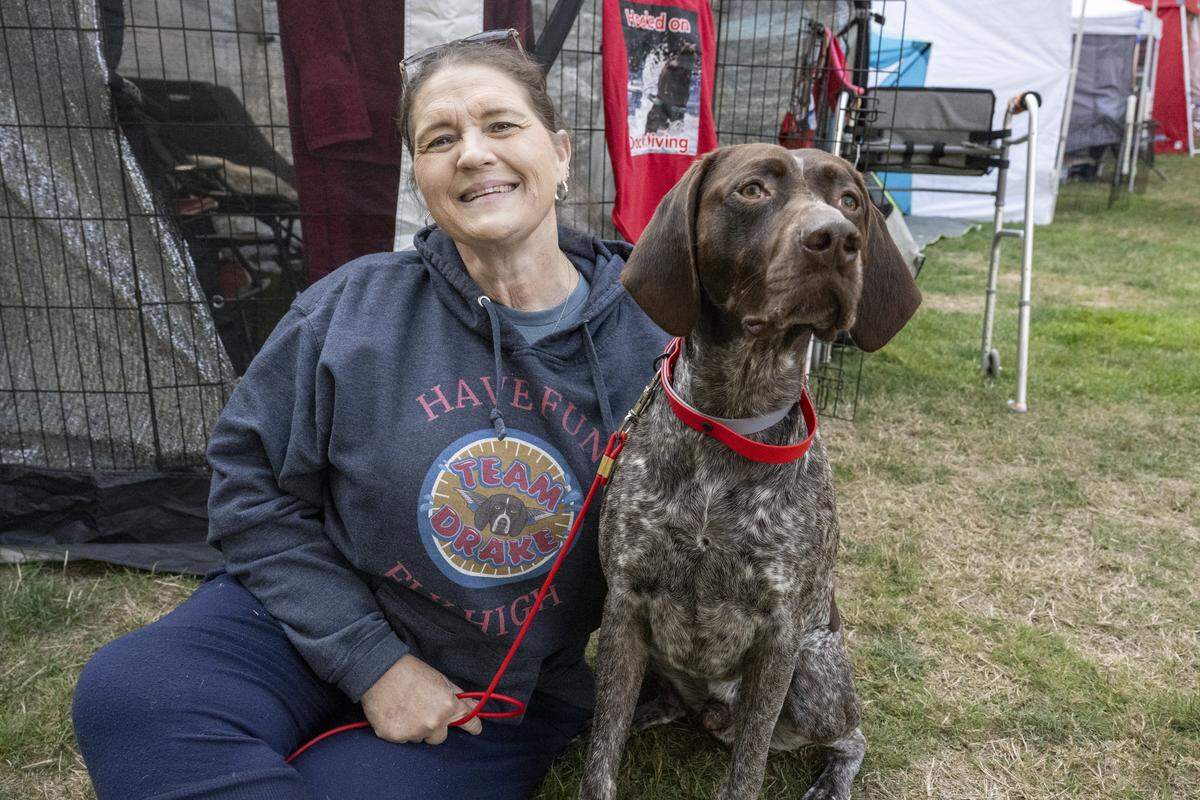 Scotque Massett sits with Drake, a German Shorthaired Pointer, between dock diving competitions on Friday, Sept. 12, 2025, at Dog Brown University on the Key Peninsula.