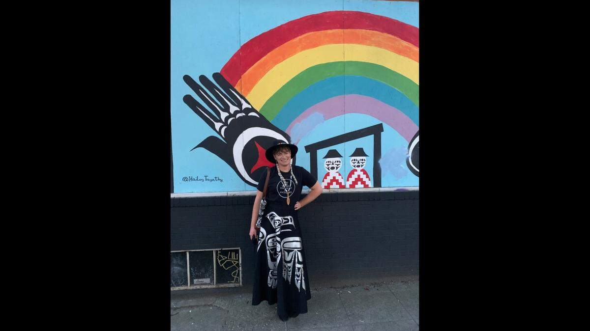 Jordan Remington, an enrolled member of the Quileute Tribe, stands in front of his art in Capitol Hill, Wash. Remington is a popular Seattle Indigiqueer icon known for performing in his drag persona, Hailey Tayathy.