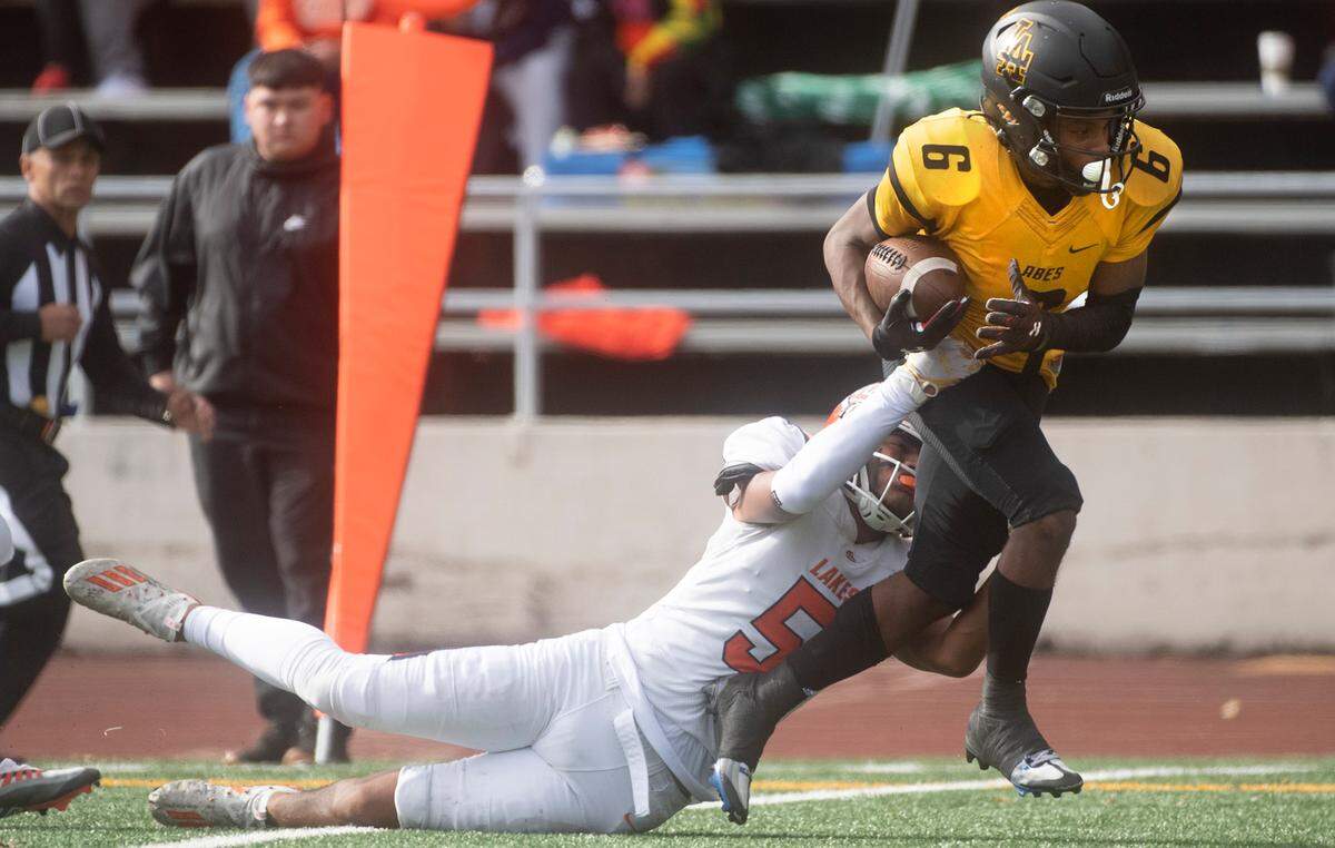 Lincoln wide receiver John John Nelson drags Lakes defensive back Chayanne Fonoti-Savea to the end zone for a touchdown reception during Saturday afternoon’s football game at Lincoln Bowl in Tacoma, Washington, on Oct. 22, 2022.