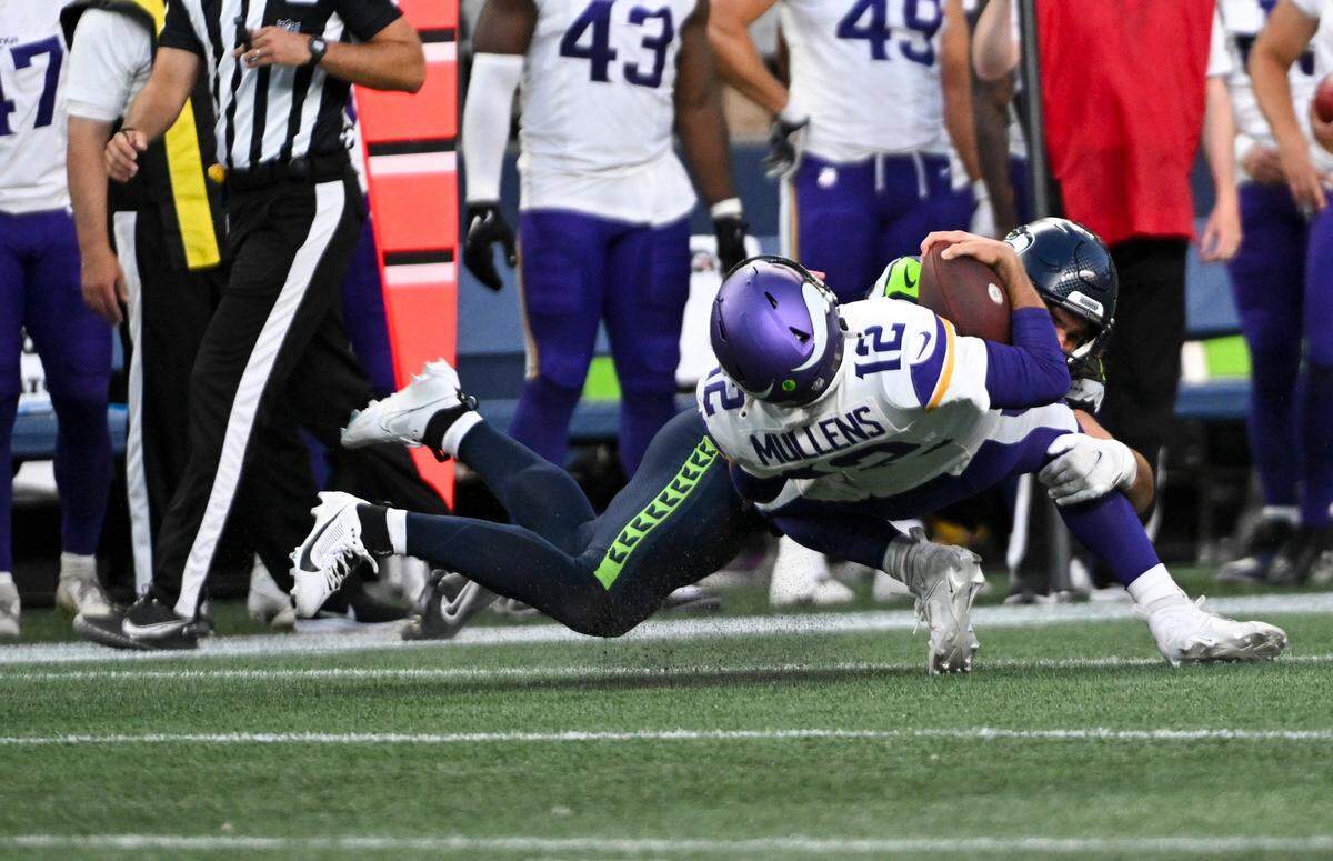 Seattle Seahawks linebacker Jon Rhattigan (59) brings down Minnesota Vikings quarterback Nick Mullens (12) during the second quarter of the preseason game at Lumen Field, Thursday, Aug. 10, 2023, in Seattle, Wash.