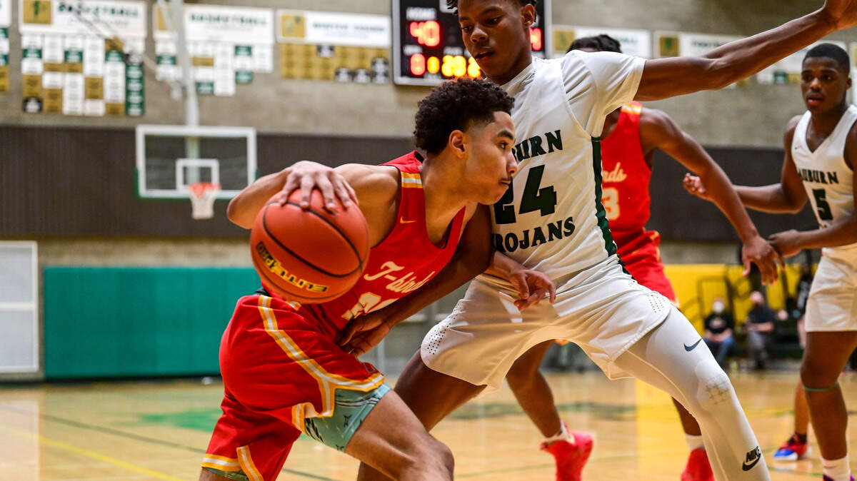 Mount Tahoma guard Asjon Anderson (20) dribbles toward the basket as Auburn guard Dae’Kwon Watson (24) defends during the third quarter of a non-league game on Thursday, Jan. 20, 2022, at Auburn High School.