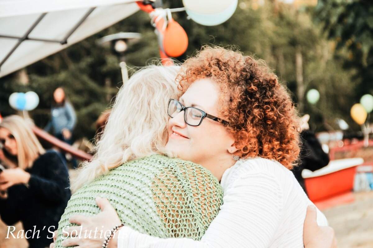 Sarah Mercer, right, hugs a friend at a church barbecue Labor Day weekend, 2018 in Olalla.