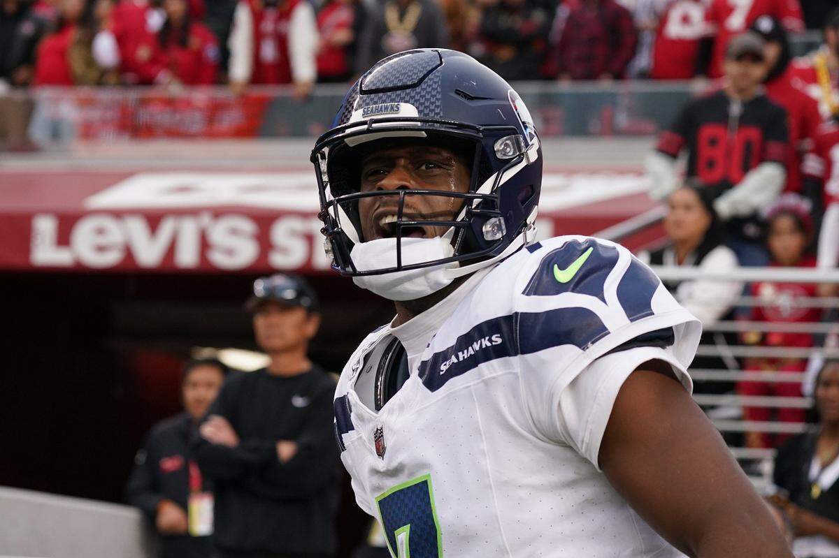 Nov 17, 2024; Santa Clara, California, USA; Seattle Seahawks quarterback Geno Smith (7) celebrates after scoring a rushing touchdown past San Francisco 49ers cornerback Isaac Yiadom (22) to win the game in the fourth quarter at Levi's Stadium. Mandatory Credit: David Gonzales-Imagn Images