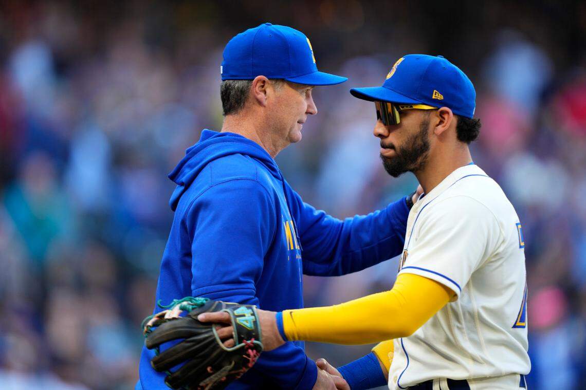 Seattle Mariners manager Scott Servais greets José Caballero as they celebrate win over the Texas Rangers in a baseball game, Sunday, Oct. 1, 2023, in Seattle. (AP Photo/Lindsey Wasson)