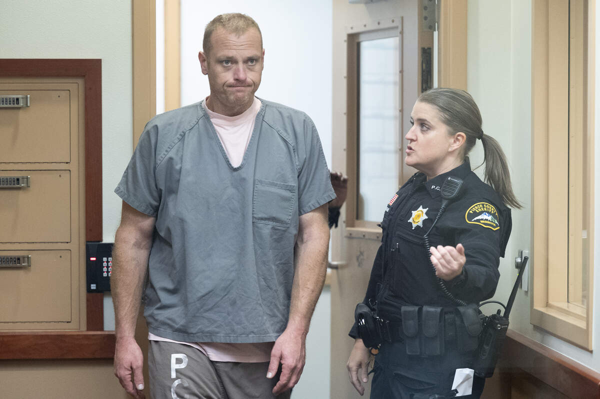 Michael Paul Courtney, left, 41, enters the courtroom for his arraignment on Monday, Oct. 13, 2025, at Pierce County Superior Court in Tacoma, Wash. Courtney is charged with first-degree murder and second-degree unlawful possession of a firearm, and is accused of fatally shooting his father Friday night in Parkland.