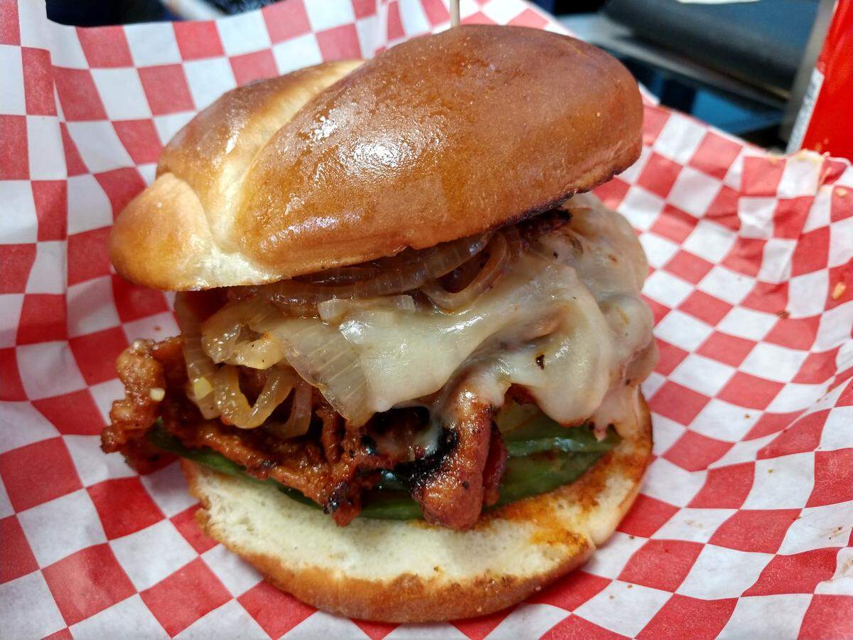 A spicy pork bulgogi burger with cucumber kimchi pickles, grilled onions and pepperjack cheese from Build-A-Burger in Tacoma.