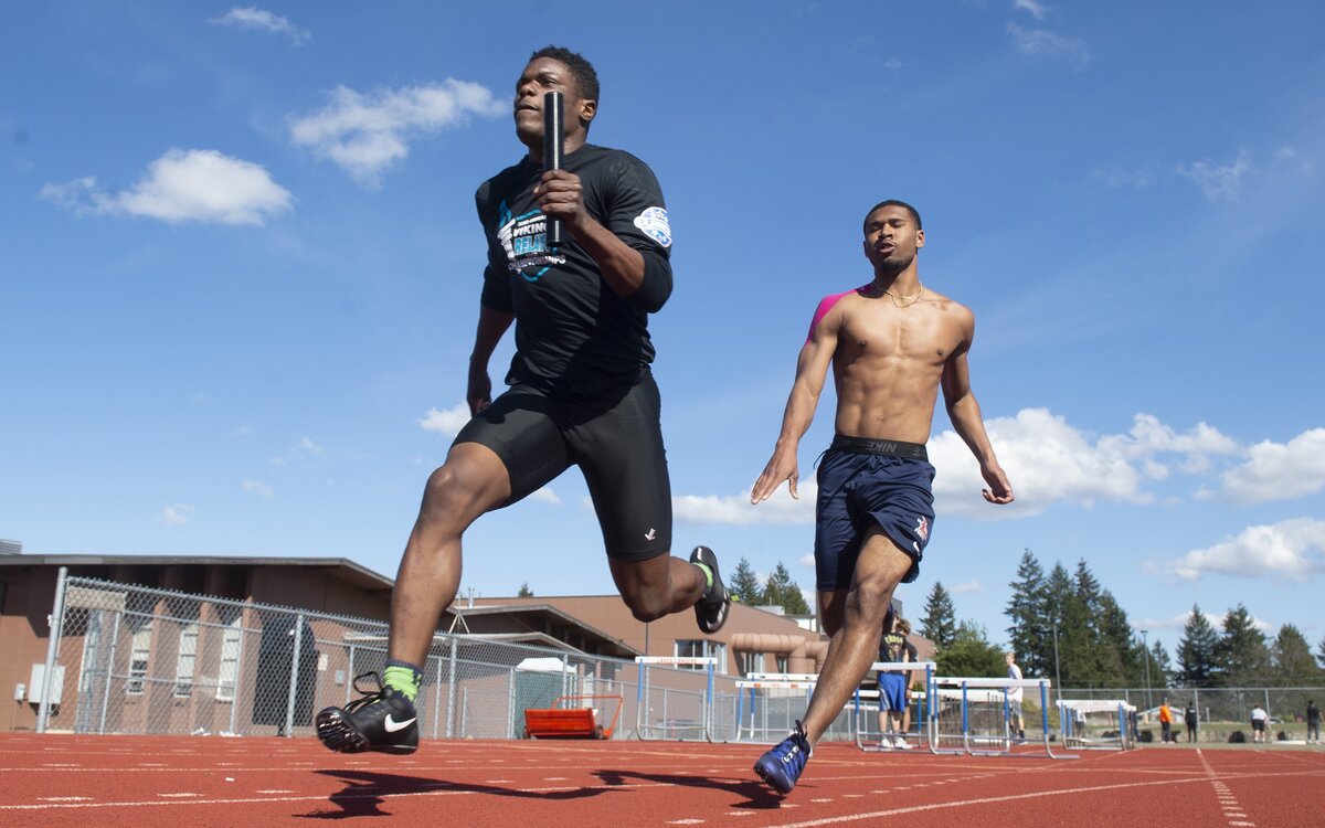 Lakes senior sprinter Dorien Simon takes the baton from fellow senior Daeshawn Wayne during track & field practice at Lakes High School in Lakewood on Tuesday, March 26, 2019.