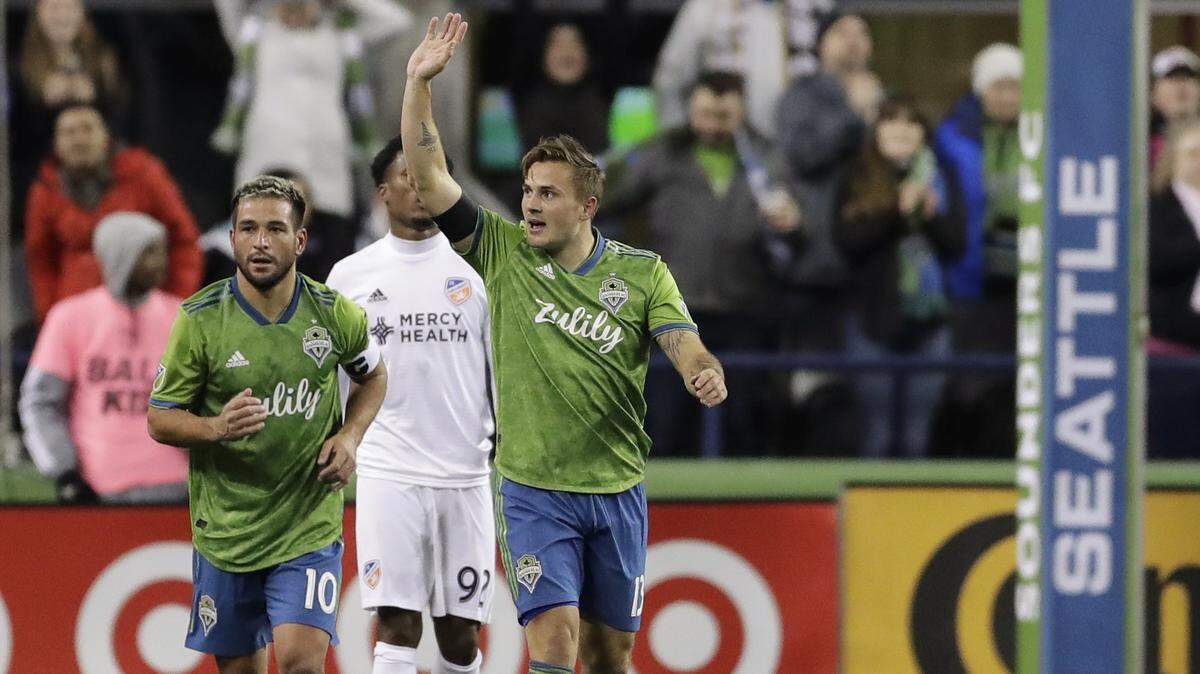 Seattle Sounders forward Jordan Morris waves to the crowd after he scored the first of his two first-half goals against FC Cincinnati during an MLS soccer match Saturday, March 2, 2019, in Seattle. Sounders’ Nicolas Lodeiro, left, assisted on the goal. (AP Photo/Ted S. Warren)