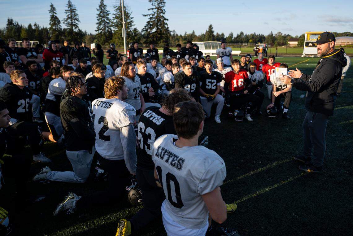 Pacific Lutheran University football head coach Brant McAdams talks with the team after practicing in the morning on the field at the school in Parkland, Wash. on Oct. 26, 2022.