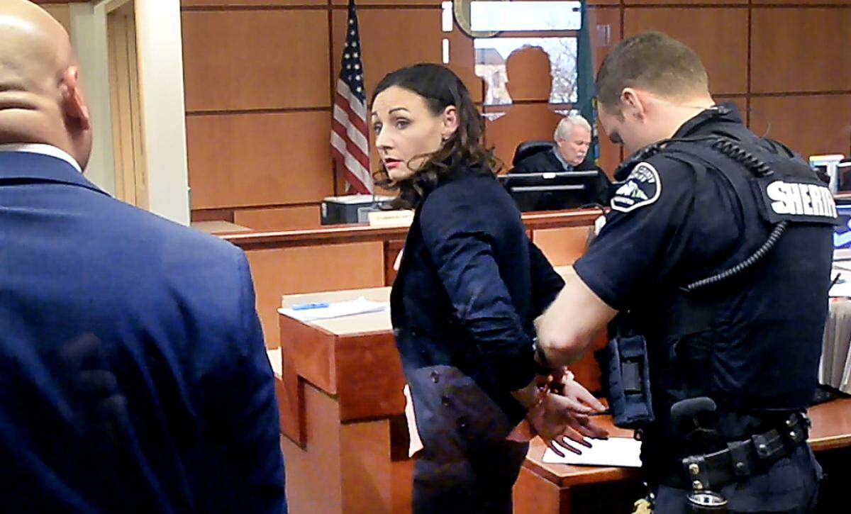 Juliette Parker looks at her attorney, left, while being handcuffed by a Pierce County sheriff’s deputy in court Tuesday, Feb. 18, 2020. Parker, who is accused of posing as a baby photographer in a plot to steal a mother’s baby, pleaded not guilty to charges of assault and attempted kidnapping. The judge raised her bail from $50,000 to $150,000.