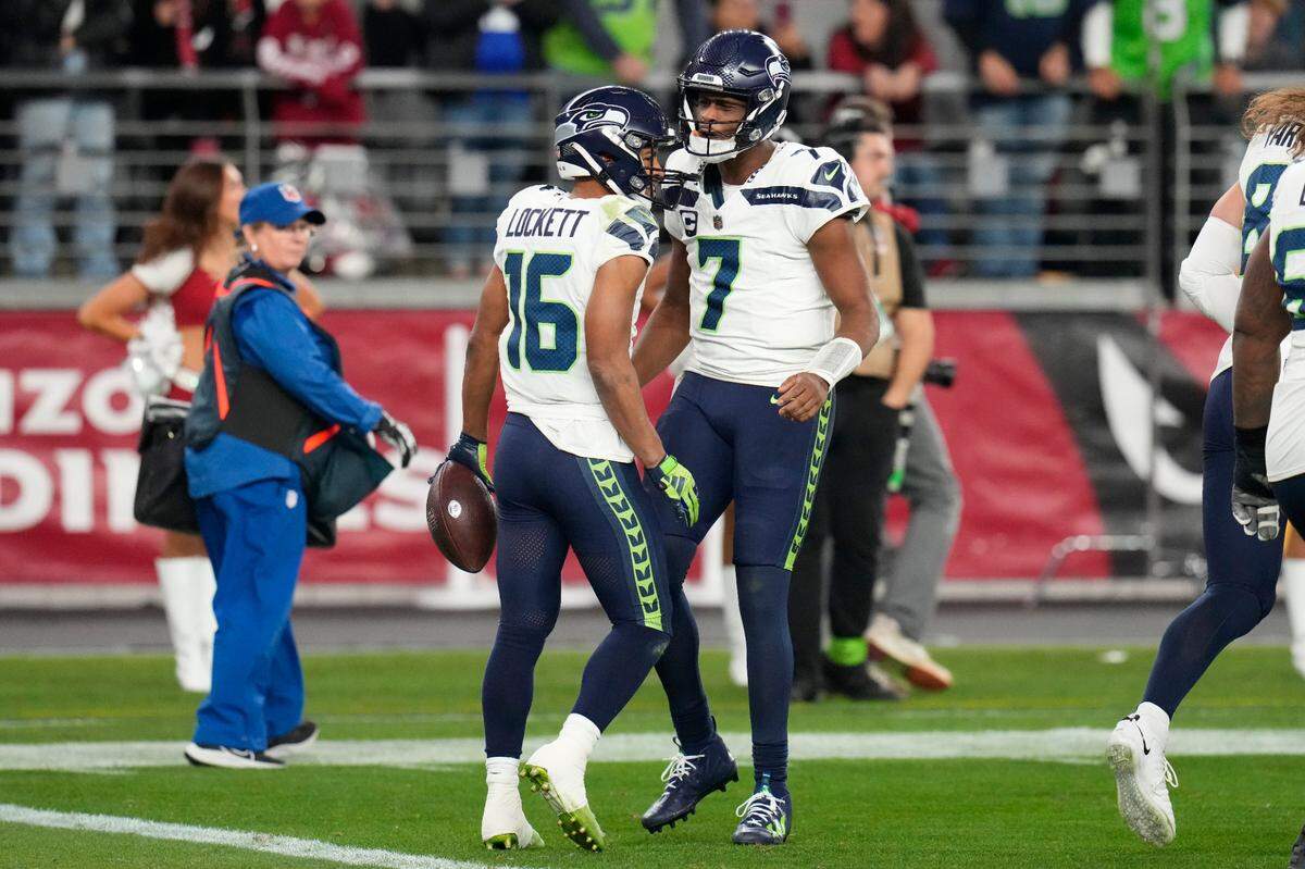 Seattle Seahawks wide receiver Tyler Lockett (16) celebrates with quarterback Geno Smith (7) after Lockett caught a two-point conversion against the Arizona Cardinals in the fourth quarter of an NFL football game Sunday, Jan. 7, 2024, in Glendale, Ariz. Lockett caught a 34-yard touchdown pass on the previous play. The score gave the Seahawks a 21-20 win. (AP Photo/Ross D. Franklin)