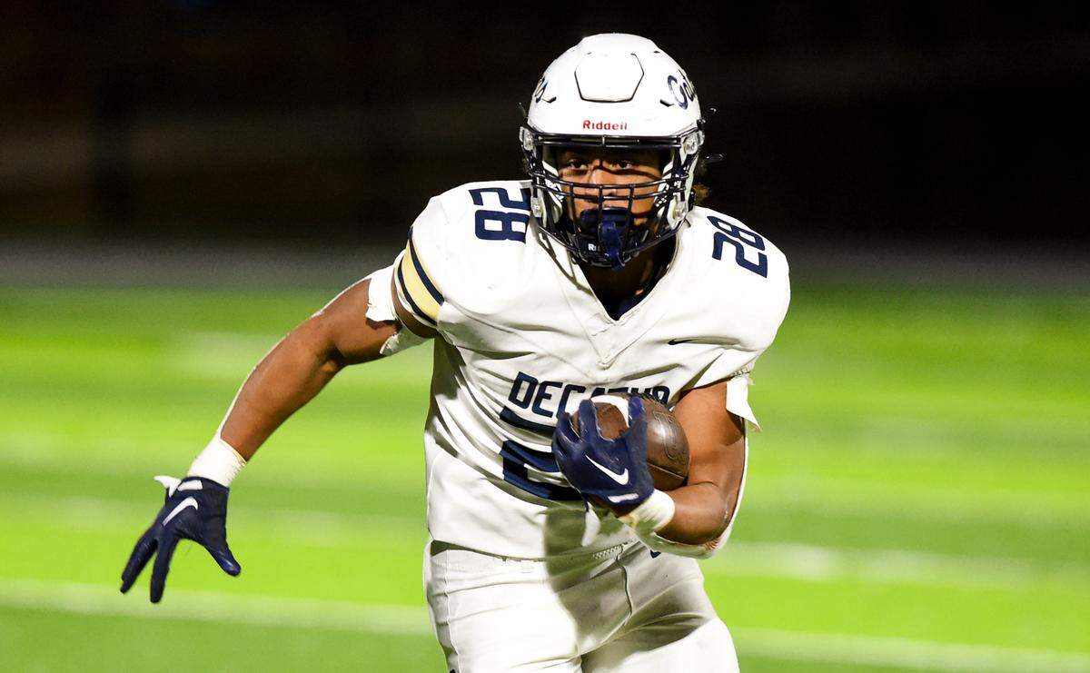 Decatur’s Nehemiah Washington (28) carries the ball against the Federal Way Eagles during the first half of the game at Federal Way Memorial Stadium, Thursday, Oct. 26, 2023, in Federal Way, Wash.