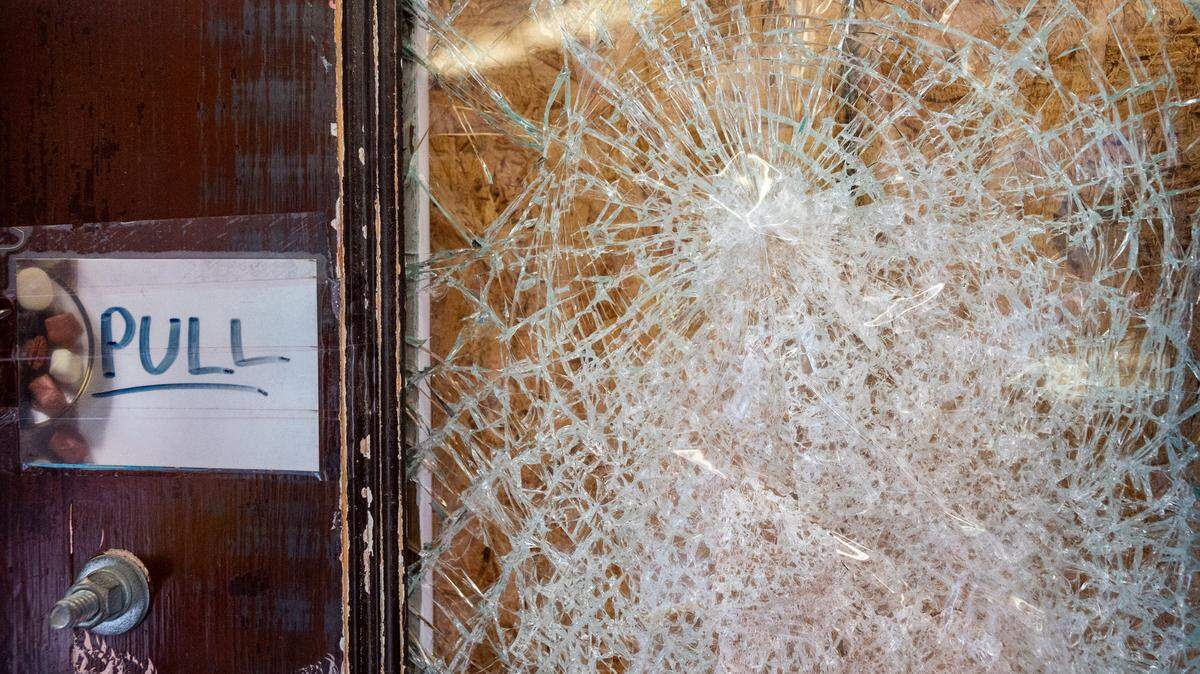 A cracked window in the front door at Johnson Candy Company is covered with a piece of plywood on Feb. 9, 2022, in Tacoma.
