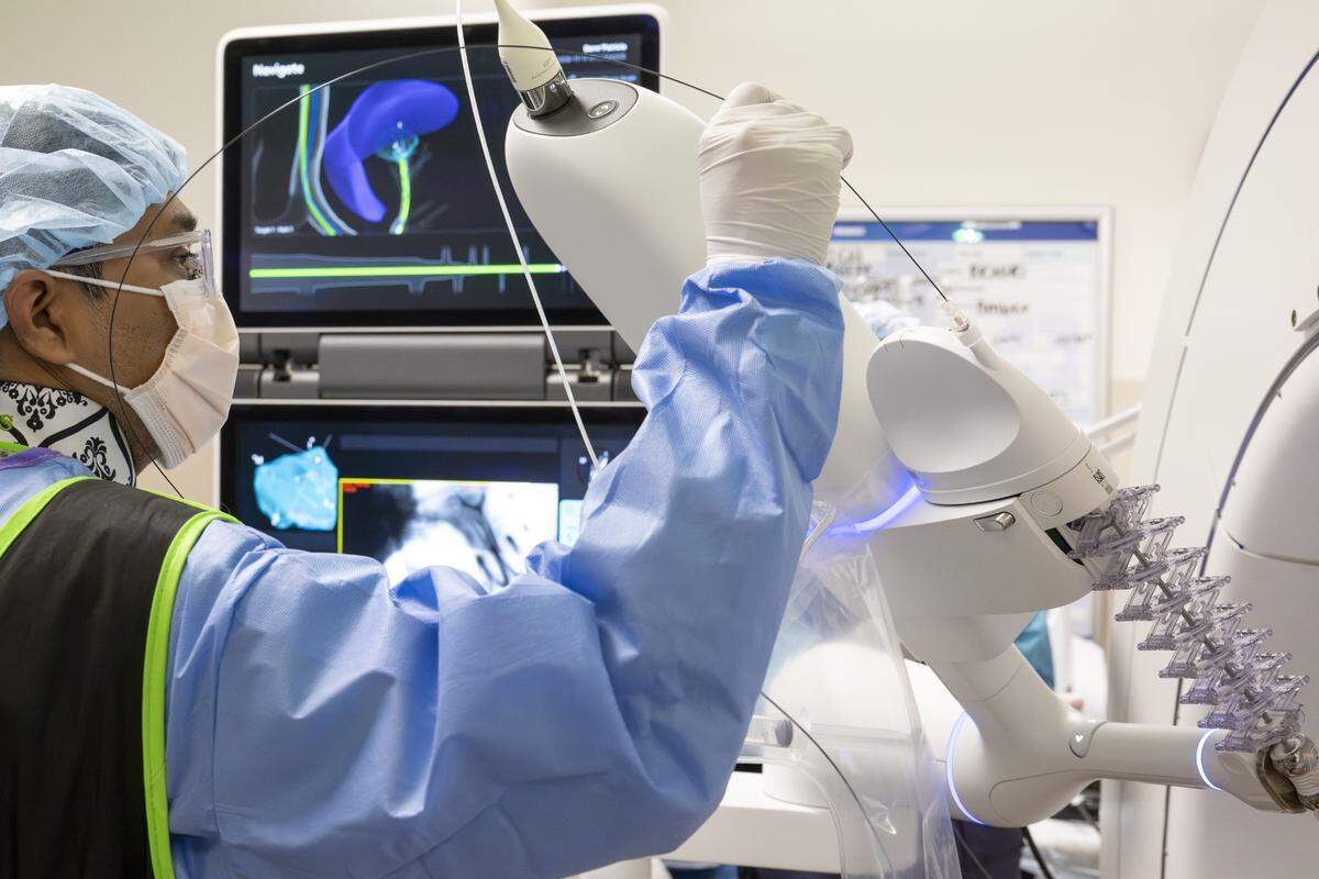 Abhishek Biswas, a pulmonologist with Multicare Health, maneuvers a catheter into the arm of a DaVinci ION robotic surgery system during a lung biopsy procedure on Wednesday, May 21, 2025, at Good Samaritan Hospital in Puyallup, Wash.