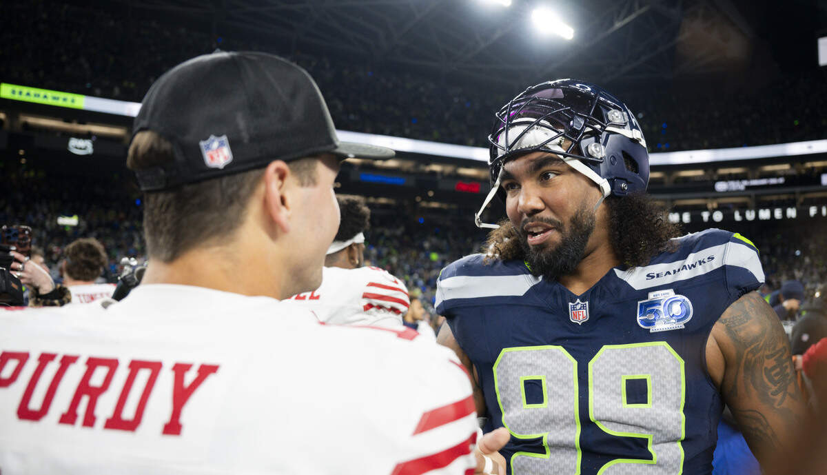 San Francisco 49ers quarterback Brock Purdy (13) and Seattle Seahawks defensive end Leonard Williams (99) talk after the Seattle Seahawks 41-6 victory against the San Francisco 49ers the NFC Divisional Round game at Lumen Field, on Saturday, Jan. 17, 2026, in Seattle.
