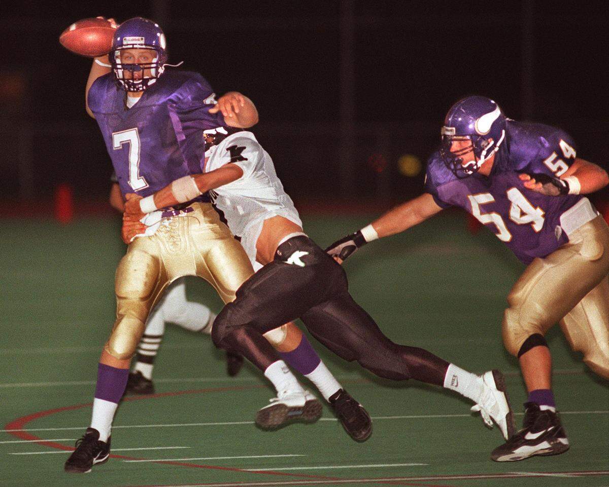 Puyallup High School quarterback Luke Huard gets the pass off as he is tackled by a Kentwood player during the first quarter of a football game on Friday, Sept. 15, 1995.