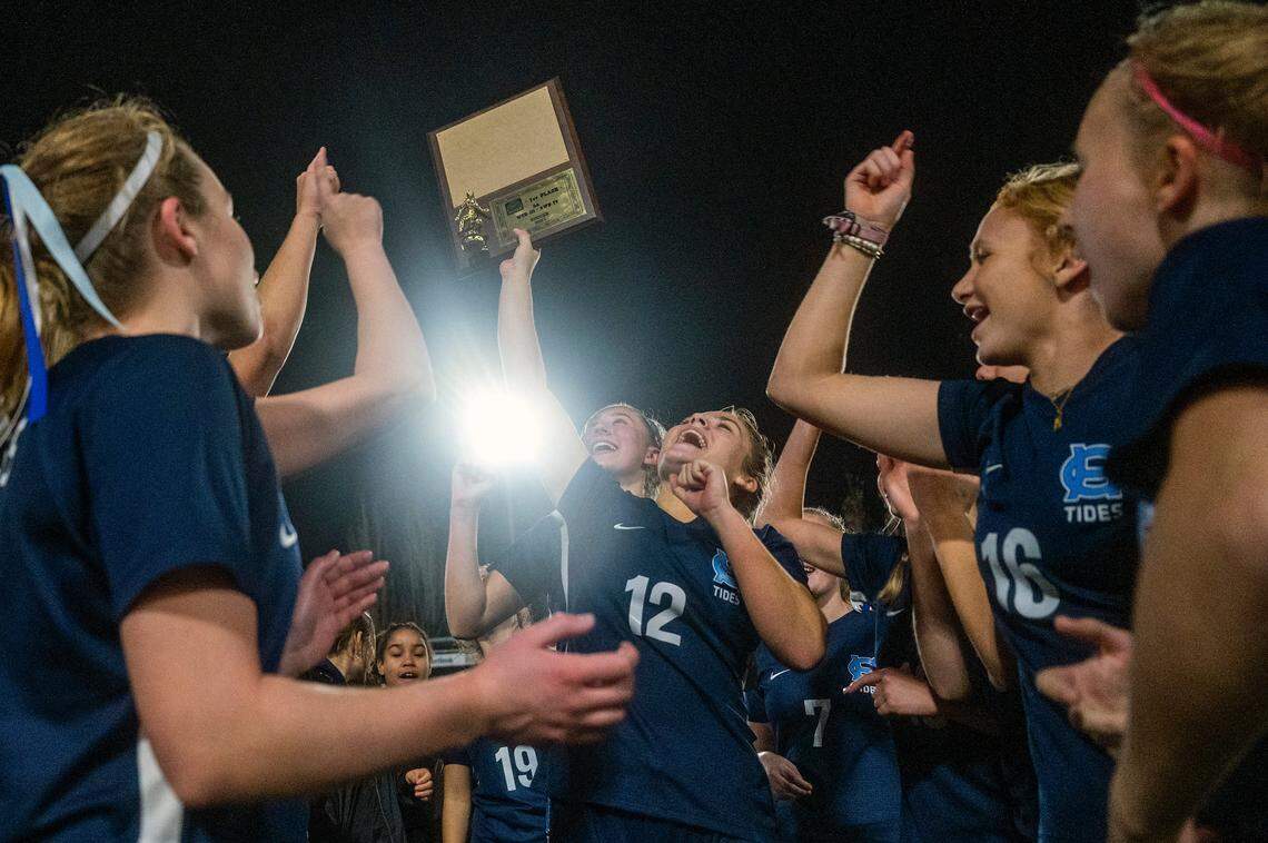 Gig Harbor’s Lily Paulson (12) hoists the trophy after the Tides beat Auburn Riverside, 2-1in the District 3/4 girls soccer championship game on Thursday night at South Sound Stadium in Lacey.