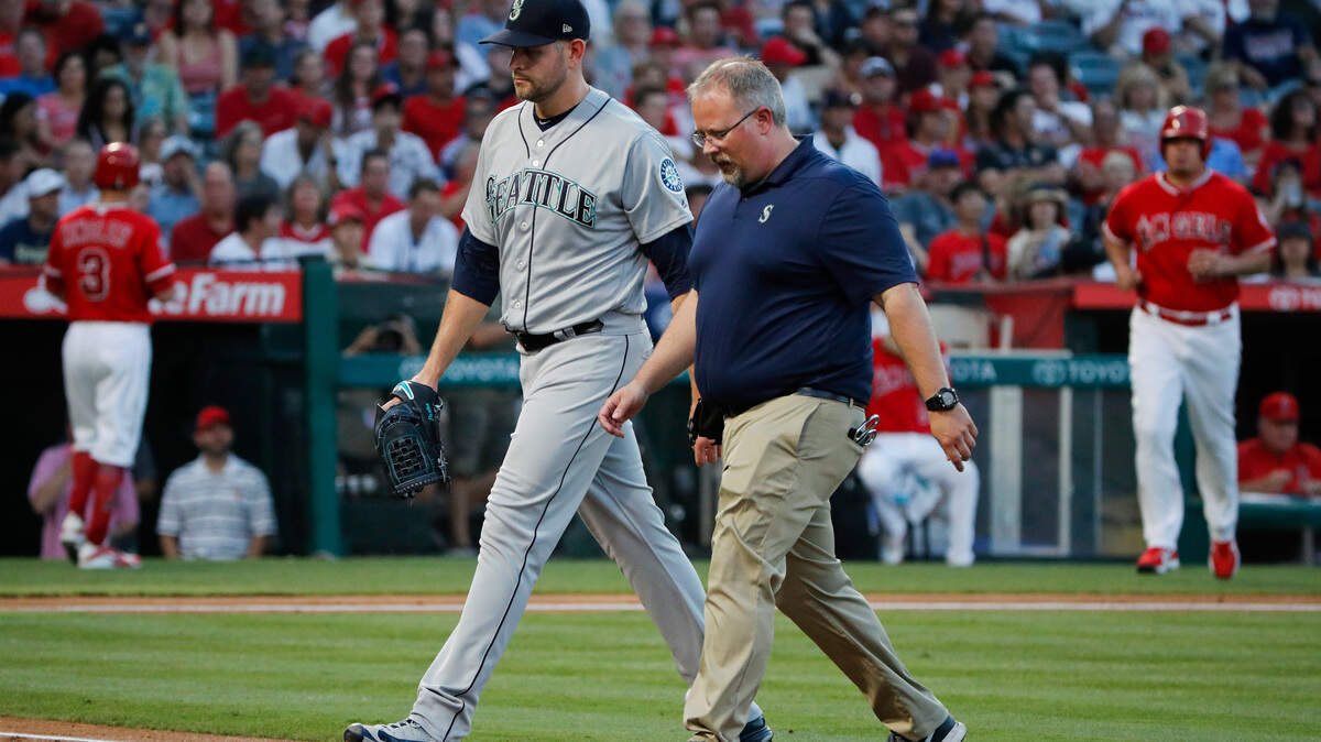 Seattle Mariners starting pitcher James Paxton, left, and a trainer walk off the field after he was removed during the first inning of the team’s baseball game against the Los Angeles Angels, Thursday, July 12, 2018, in Anaheim, Calif. (AP Photo/Jae C. Hong)