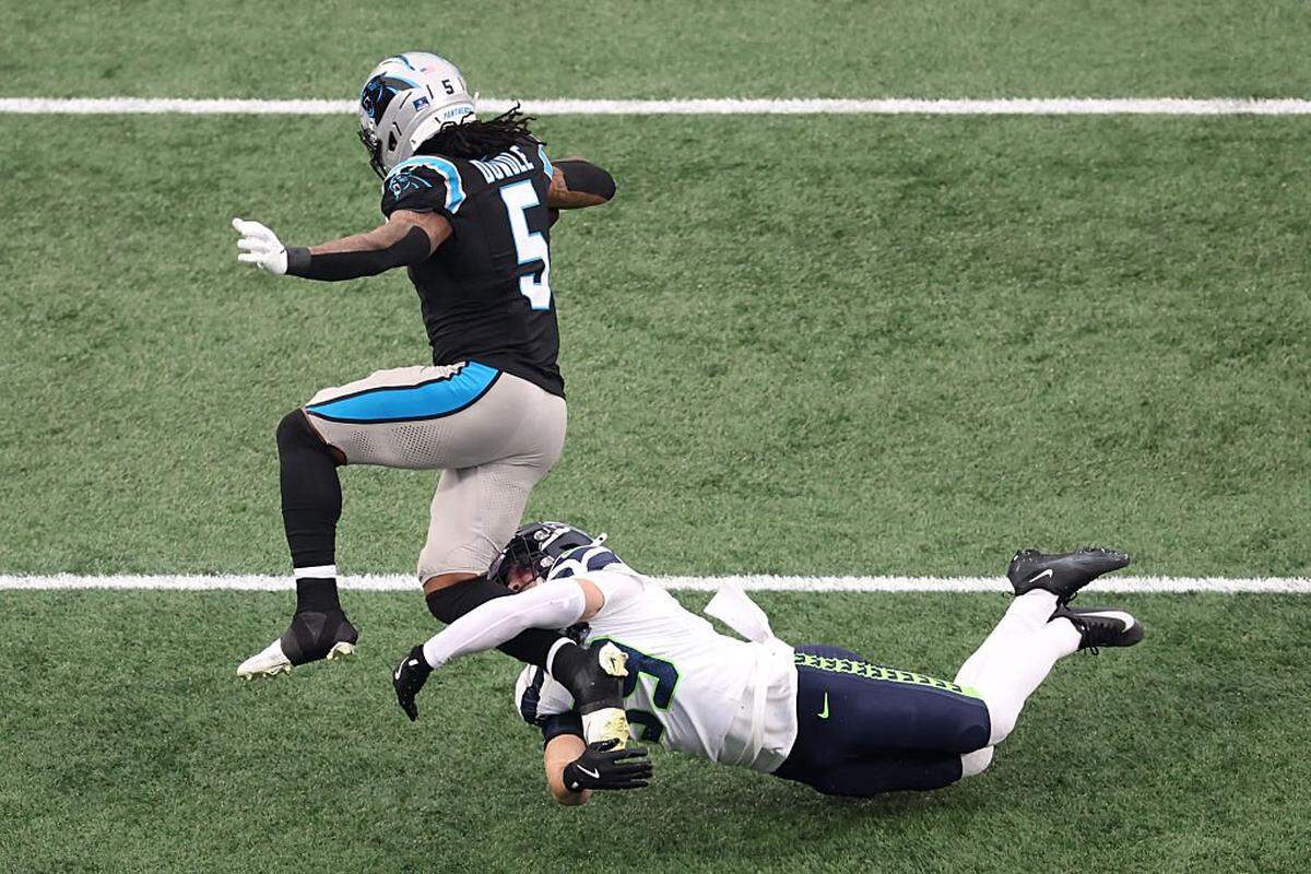 CHARLOTTE, NORTH CAROLINA - DECEMBER 28: Ty Okada #39 of the Seattle Seahawks tackles Rico Dowdle #5 of the Carolina Panthers during the first quarter at Bank of America Stadium on December 28, 2025 in Charlotte, North Carolina. (Photo by David Jensen/Getty Images)