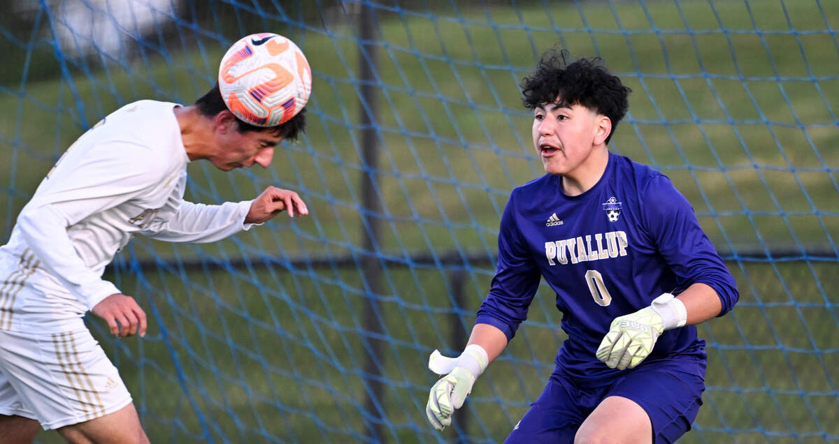Puyallup midfielder Tyler Buckler (9) heads the ball away from the goal as Puyallup goalkeeper Alexis Cruz-Hernandez (0) watches on during the match against Bellarmine Prep at Bellarmine Preparatory School, on Tuesday, April 16, 2024, in Tacoma, Wash.