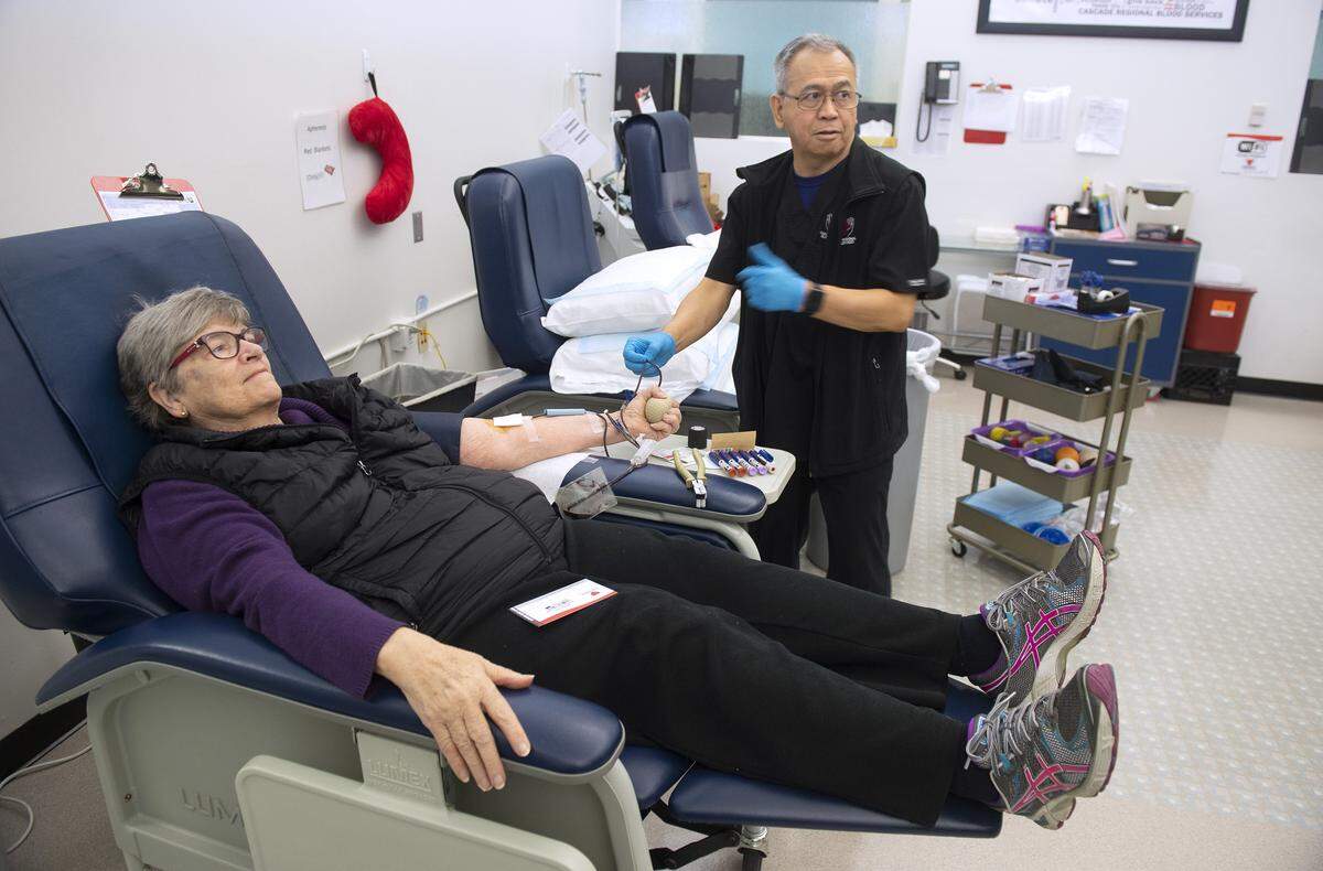 Mary Ruth Pape of Fircrest is assisted by donor specialist Leo Arellano as she donates blood at Cascade Regional Blood Services in Tacoma on Feb. 19, 2019.