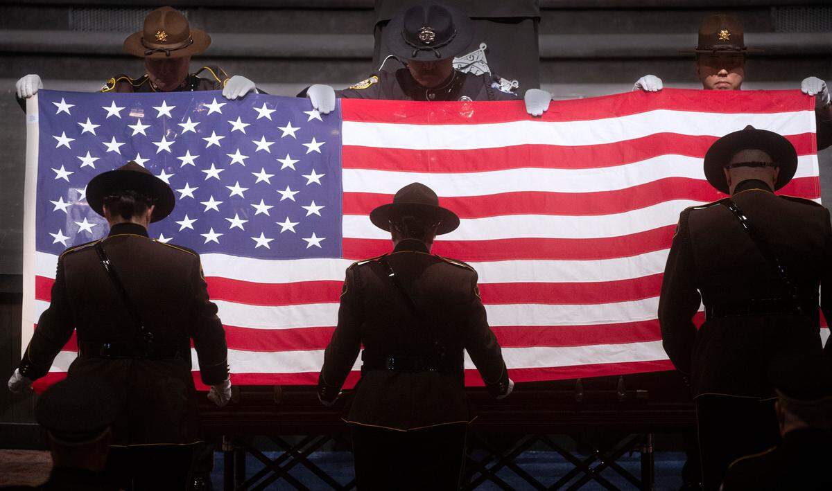 Flag detail team folds the American flag that covered the casket of Pierce County sheriff’s deputy Dom Calata at the closing of the celebration of life at Church For All Nations in Parkland on Friday, March 25, 2022.